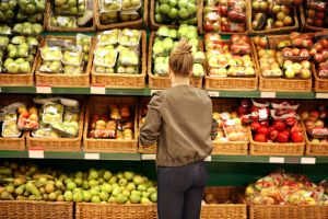woman at farm shop browsing selection of fruit